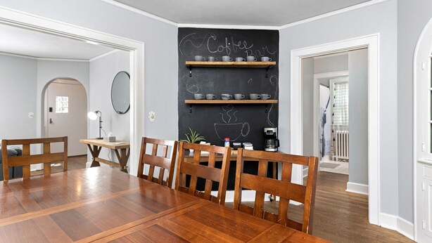 A dining area with a wooden table and chairs, a blackboard with coffee-related drawings, and a coffee machine. - The Hawksbill Haus (w/ hot tub) (Waynesboro)