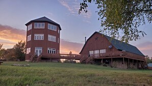 Ein zweistöckiges Holzhaus mit Balkon und einer Scheune.