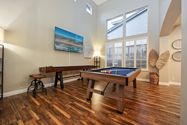 A pool table in a room with hardwood floors, a large window with blinds, and a painting on the wall. - 10 min walk to the beach, hot tub and pool table - Dolphin's Cove in Leucadia (Encinitas)