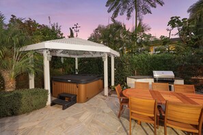 An outdoor patio with a wooden table and chairs, a hot tub, and a barbecue grill. - 10 min walk to the beach, hot tub and pool table - Dolphin's Cove in Leucadia (Encinitas)