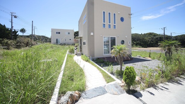 A modern two-story house with a pathway leading to the entrance.