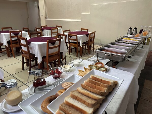 A buffet setup with various food items and beverages. - HOTEL PASTORA (Córdoba)