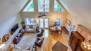 A spacious loft with a high ceiling, a dining area, a kitchen, and a living room with multiple seating options. - Waterfront Eatonton Escape w/ Private Hot Tub! (Eatonton)