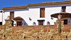 Un edificio tradicional con fachada blanca, base de piedra y tejas de arcilla.