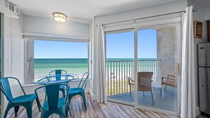 A room with a glass door leading to a balcony with a view of the ocean. - 🚤Belleair Beach Club #313 – Cozy Gulf-Front Condo with Stunning Views & Heated Pool!🩱 (Belleair Beach)