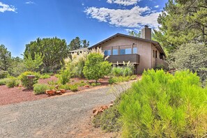 A modern house with a driveway, surrounded by landscaped greenery and trees. - Patio & Panoramic Desert Views: Sedona Getaway! (Sedona)