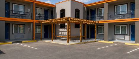 Un edificio de varios pisos con un patio central, balcones y una zona de estar techada.