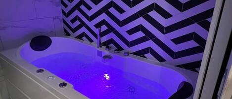 Bathtub, hair dryer, towels, shampoo