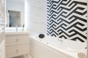 Bathtub, hair dryer, towels, shampoo