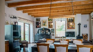 Un coin repas chaleureux, avec des meubles en bois, un buffet noir et une cheminée.