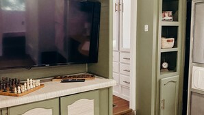 A kitchen with a TV, chessboard, and cabinets. - The Pendle-Tin (Pendleton)