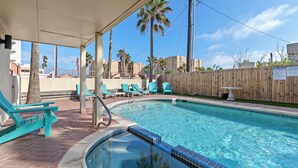 A swimming pool with a tiled edge, surrounded by turquoise lounge chairs and a wooden fence. - Spacious Beachside Home with Private Pool! Dog-Friendly & Directly Across from Beach! (South Padre Island)
