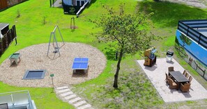 Ein Spielplatz mit Schaukeln, einer Wippe und einem kleinen Tisch mit einer Solaranlage.