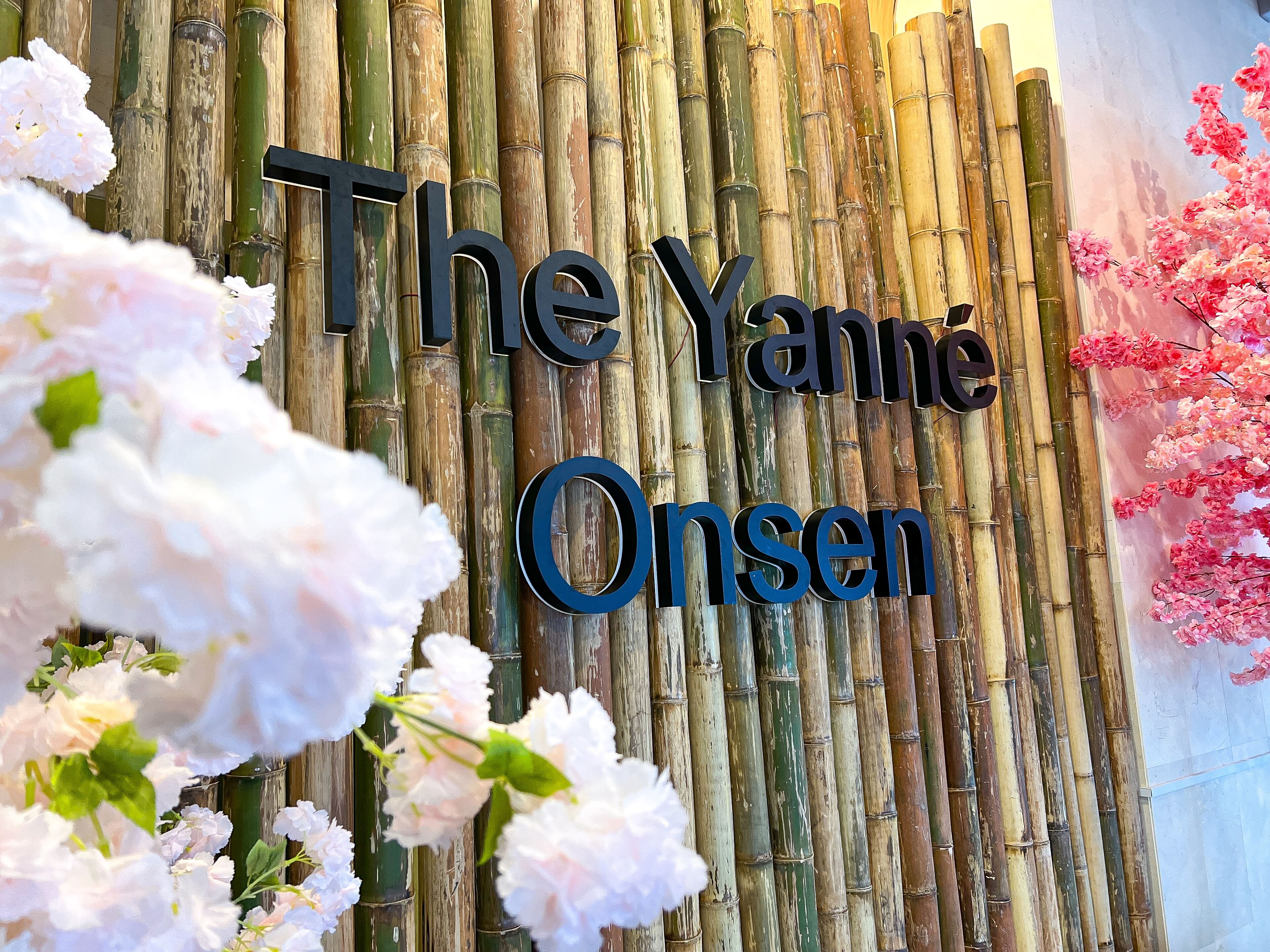 Paret de bambú amb el text "The Yanne Onsen" al centre.
