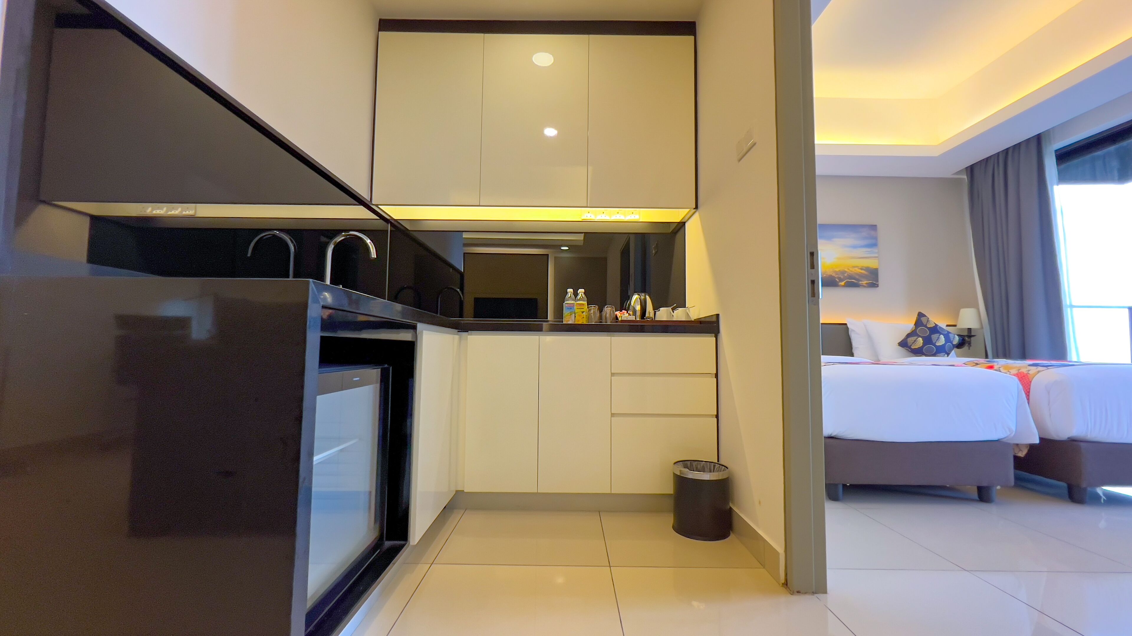 Una habitación de hotel moderna con kitchenette, una cama con vistas y un baño.