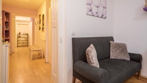 A living room with a grey sofa, a chair, and a wall-mounted artwork. - Apartment 'Seenaah Lindau 9' 3 Minutes from the Lake with Wi-Fi, No Kitchen (Lindau)