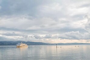 A boat on a calm lake with mountains in the background.
