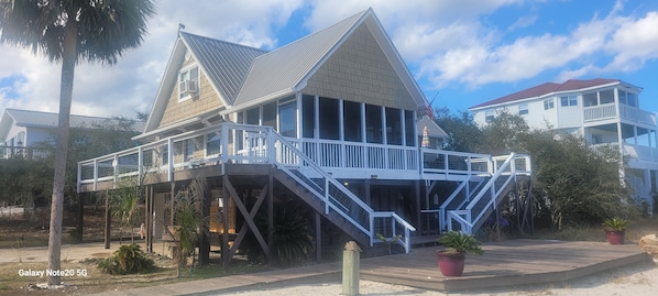 A two-story house with a balcony and a staircase leading to the upper floor.