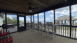 A covered outdoor area with a ceiling fan, large windows, and a view of the beach and ocean. - Beach Getaway Just Refreshed, Sleeps 8 <4 br> EV level 2 charging- views (Alligator Point)
