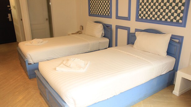A hotel room with two beds, each with a blue headboard and white bedding. - Kudos Boutique Hotel (Pattaya)