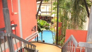 A staircase leading to a pool area with a view of a building in the background. - Kudos Boutique Hotel (Pattaya)