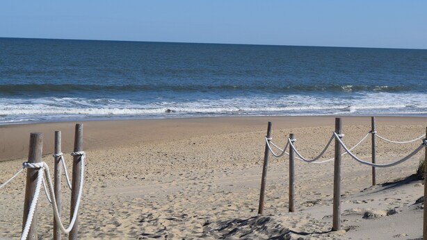 A sandy beach with wooden posts and ropes, leading to the ocean. - Dewey Beach Ocean Block Condo Elevator Parking Sleeps 10 (Dewey Beach)