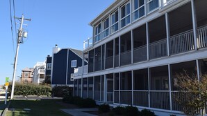 A two-story building with a balcony on the second floor. - Dewey Beach Ocean Block Condo Elevator Parking Sleeps 10 (Dewey Beach)