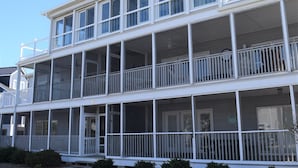 A two-story building with multiple balconies and a covered porch area. - Dewey Beach Ocean Block Condo Elevator Parking Sleeps 10 (Dewey Beach)