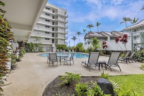 Relax by the pool surrounded by lush greenery and comfortable lounge seating.