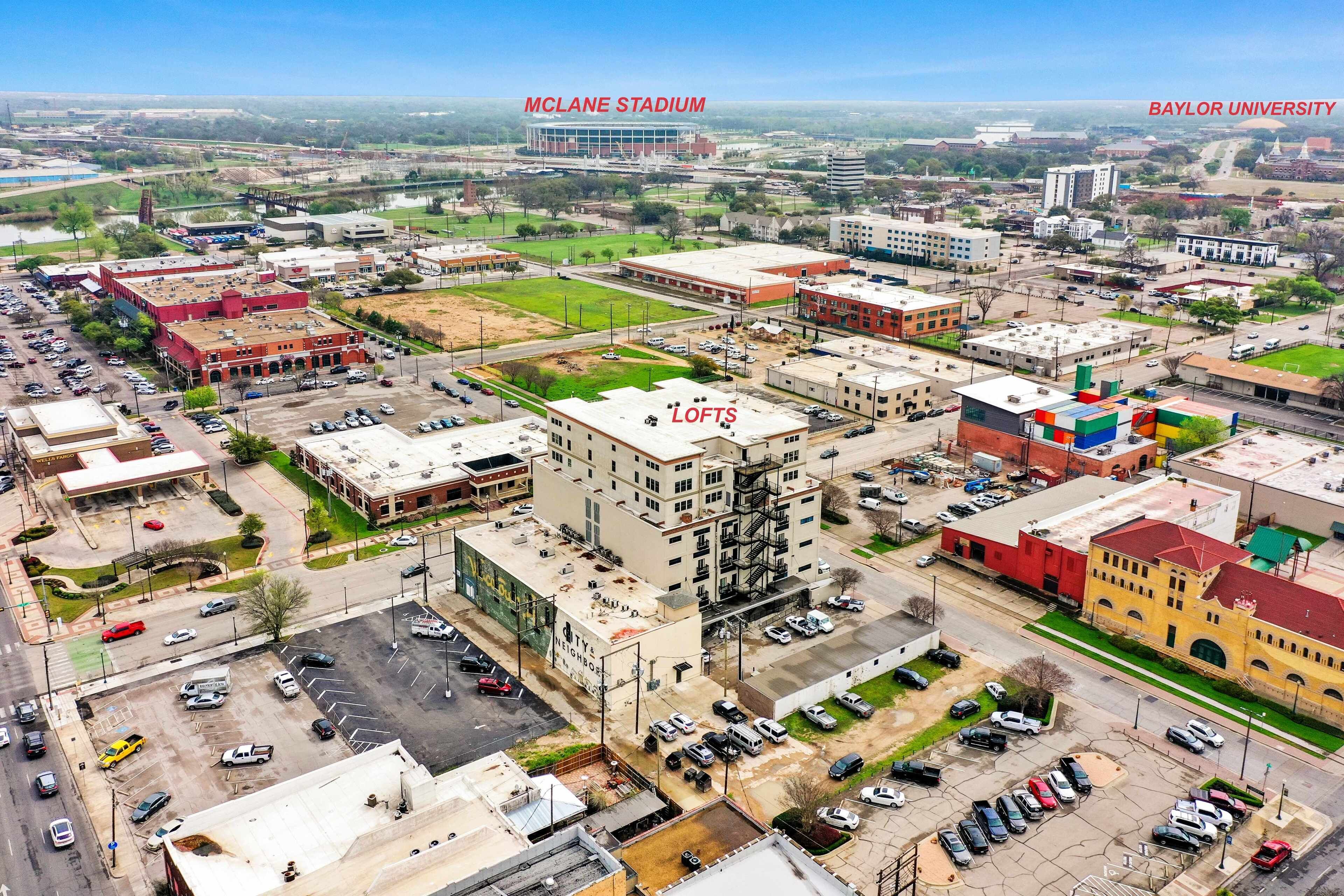 A cityscape with a prominent building labeled "LOFTS" and "BAYLOR UNIVERSITY" in the background.