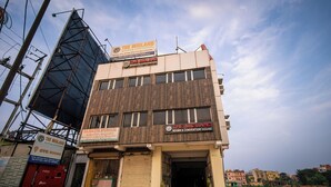 Un edificio con diversi cartelli pubblicitari che recano le scritte 'The Midland Rooms & Convention' e 'Rajbaiya Ayurveda'.