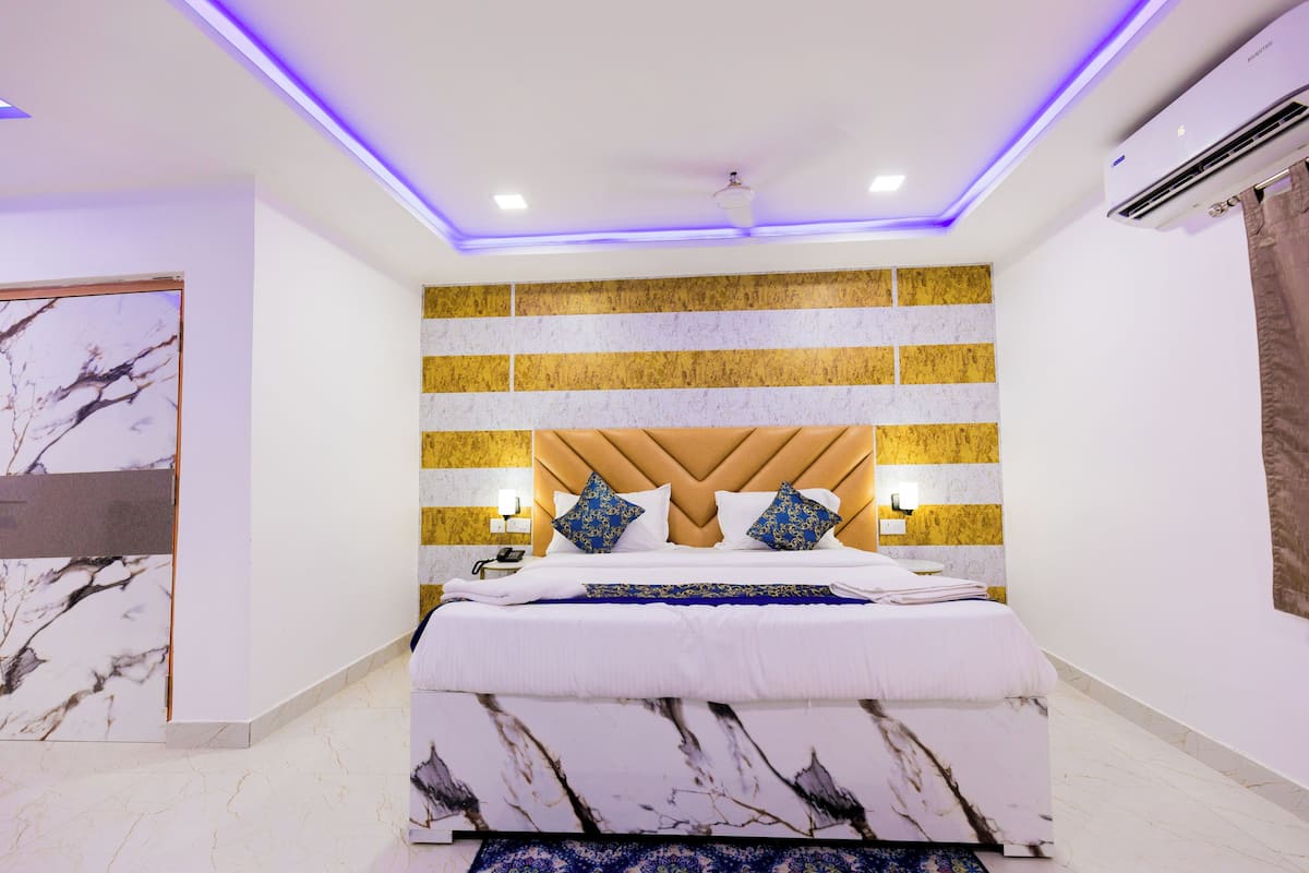 A modern bedroom with a bed, a headboard, and a wall-mounted air conditioner.