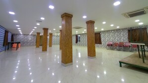 Un'ampia sala con soffitti alti, diverse colonne e un muro decorato.