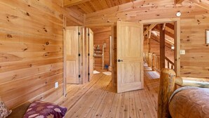A wooden cabin interior with a loft bedroom, a wooden staircase, and a visible closet. - Starry Mountain Night | Seasonal Private Pool + Pool Table, Kid`s Playset (Stanton)