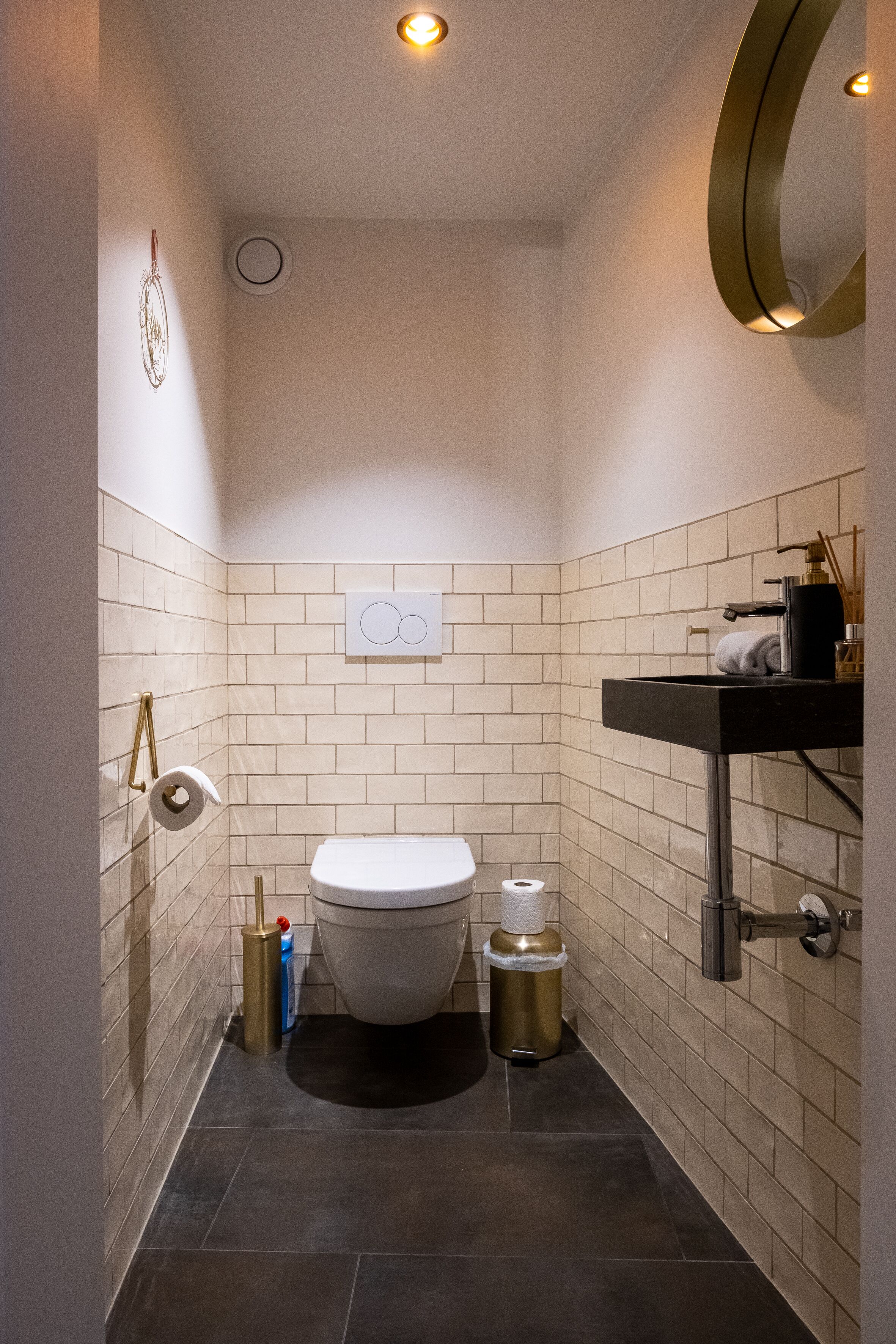 Une petite salle de bain comprenant des toilettes, un lavabo et un miroir.