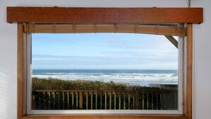A window with a view of the ocean and a wooden fence. - New Listing! Cozy beachfront home on famed Heceta Beach, amazing sunsets (Florence)