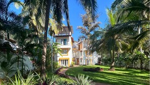 Un hotel con un patio central rodeado de exuberante vegetación y palmeras.