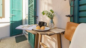 A wooden table with a book, a mug, and a plate with two pastries. - Via Muralto 13 in Como (Como)