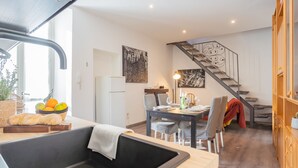A modern kitchen with a dining area, a staircase, and a view of the outdoors. - Via Muralto 13 in Como (Como)