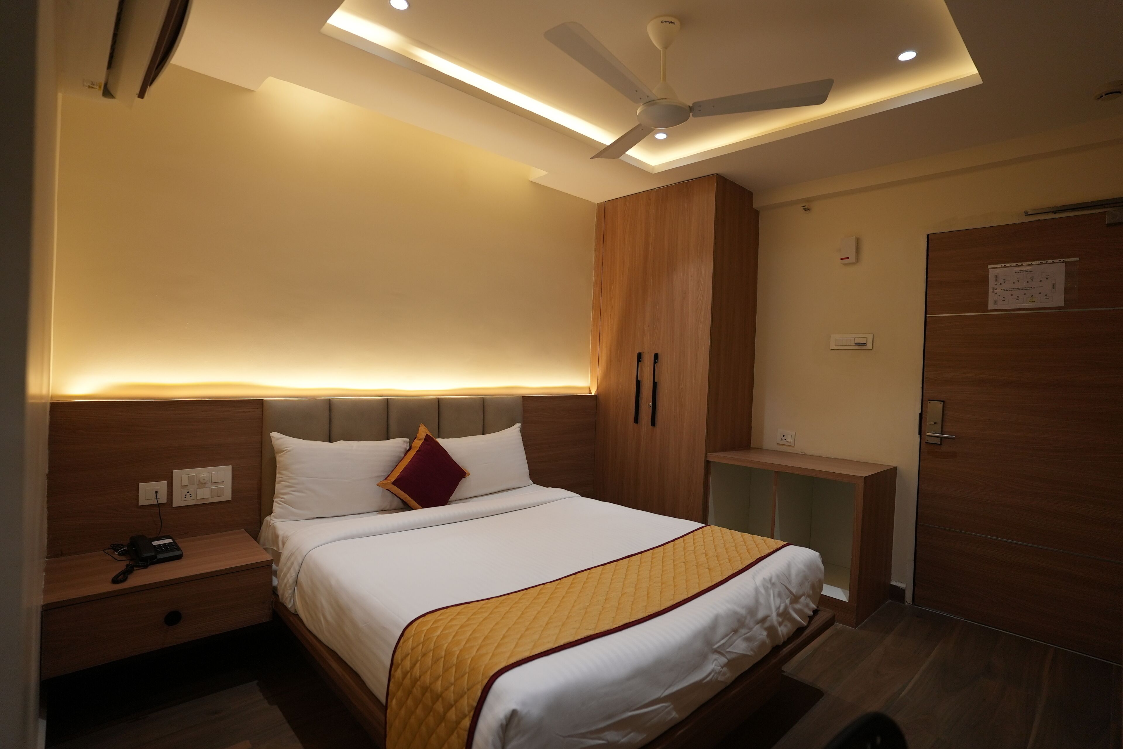 Ein modernes Hotelzimmer mit einem großen Bett, einem Nachttisch und einem Kleiderschrank.