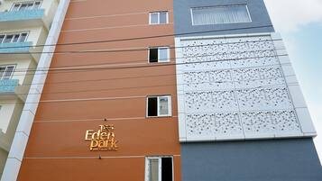 A multi-story hotel with a prominent orange facade and a sign reading "The Eden Park Boutique Hotel."