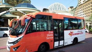 A red and white bus with "Free Shuttle Service" and "Sunway City" branding parked on a paved area. - Industrial Suites at Bandar Sunway (Petaling Jaya)