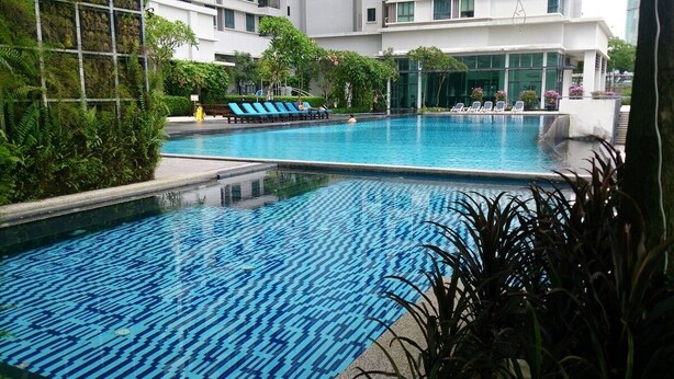 A swimming pool with blue patterned tiles, surrounded by lounge chairs and greenery. - Industrial Suites at Bandar Sunway (Petaling Jaya)