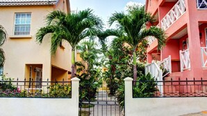 A gated entrance with a pathway leading to a building with a balcony. - Villa located in St James on the west cost of Barbados with sea view and pool. (Fitts Village)