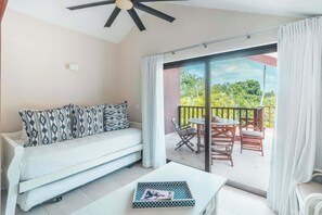 Un salon moderne avec un canapé, une table basse et un balcon équipé d’une table et de chaises.