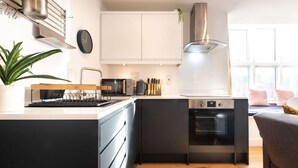 Una cucina moderna con forno integrato, macchina del caffè e bollitore sul piano di lavoro.