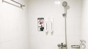 A small, clean bathroom with a toilet, a shower, and a hand dryer.