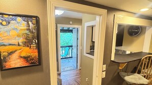 A hallway with a painting, a wooden chair, and a clock on the wall. -  Amazing Suite w Fireplace & Washer & Dryer! Pets & 420 Friendly (Gatlinburg)
