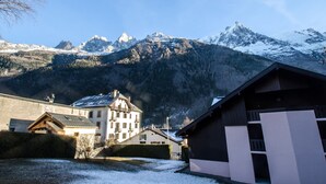 Un village de montagne aux bâtiments traditionnels, offrant une vue sur des sommets enneigés.