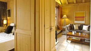 Une pièce comprenant un lit, une armoire en bois, un canapé, une table basse et une lampe.